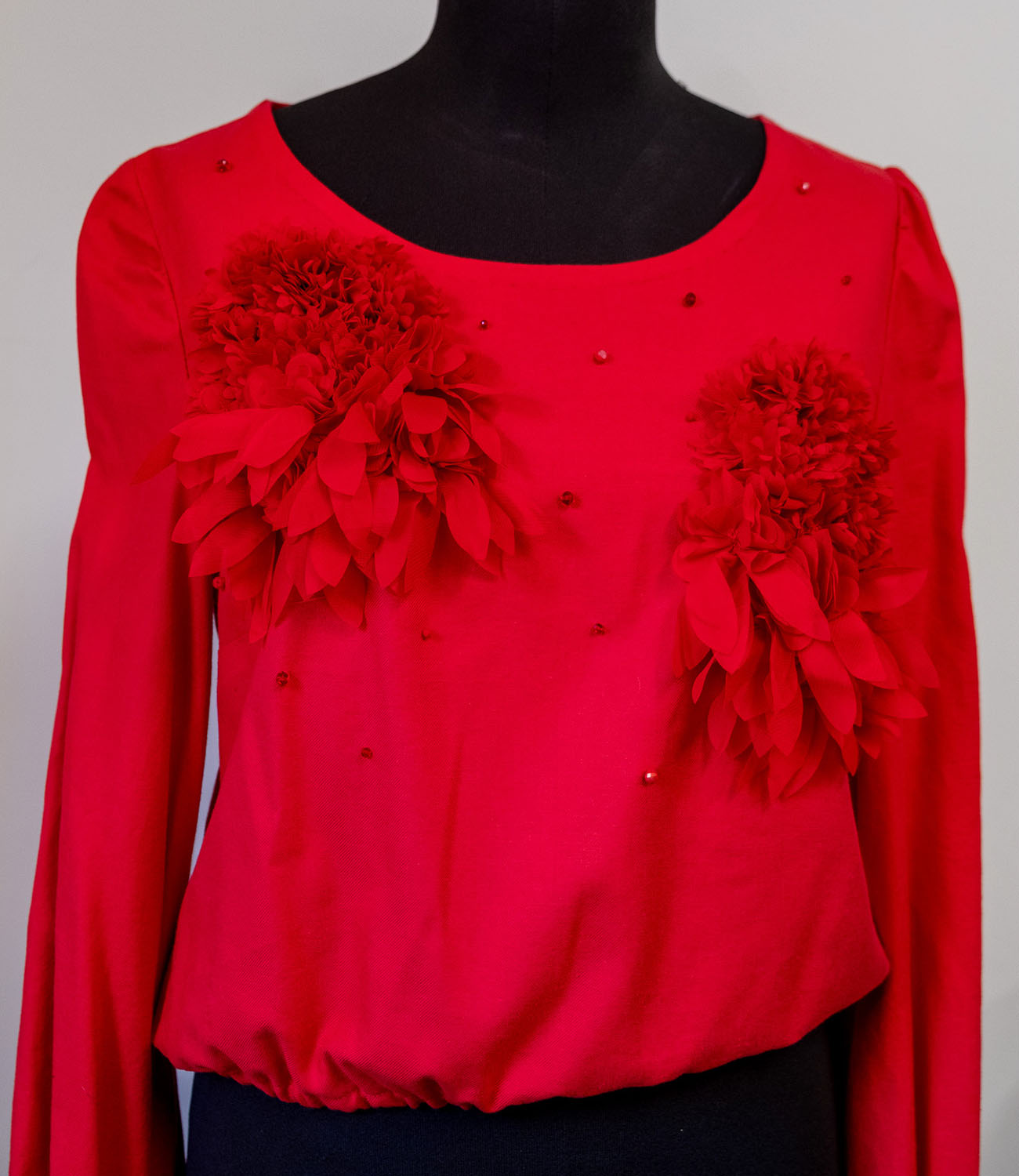 Blusa rossa con applicazioni floreali realizzata durante il Corso Sartoria