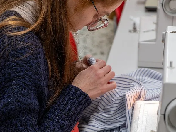 Studentessa del corso di taglio e cucito alla macchina da cucire